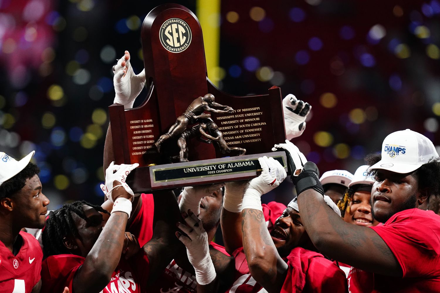The Alabama Crimson Tide celebrate with the SEC championship trophy after defeating the Georgia Bulldogs at Mercedes-Benz Stadium.
